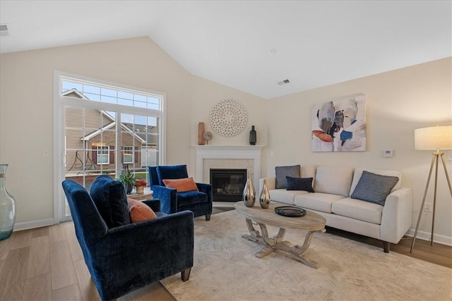 living room with light hardwood / wood-style flooring and lofted ceiling