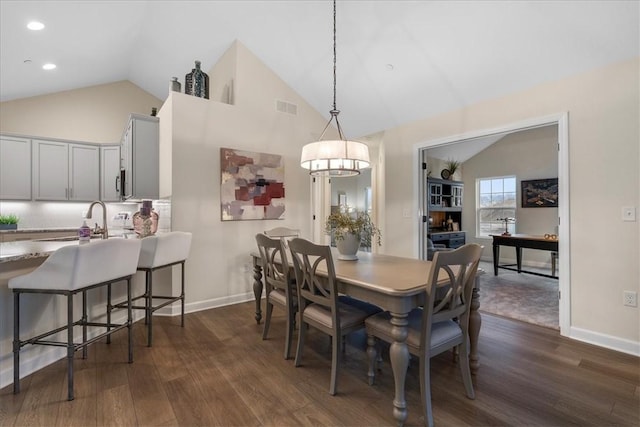 dining area featuring dark hardwood / wood-style flooring, sink, and vaulted ceiling