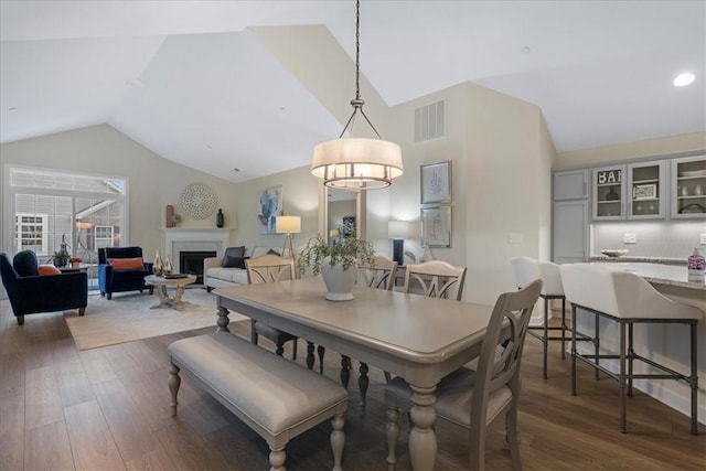 dining space featuring dark hardwood / wood-style floors and vaulted ceiling