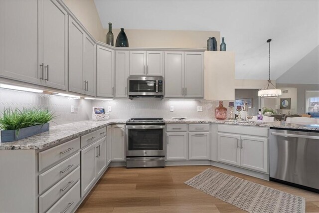 1111 Forest Oaks Dr, Center Twp, PA 16001 - kitchen with appliances with stainless steel finishes, vaulted ceiling, backsplash, light wood-style floors, and a peninsula