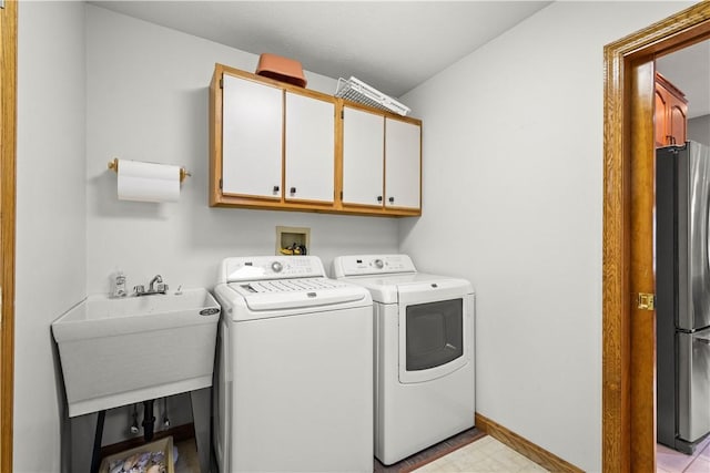 clothes washing area with cabinets, independent washer and dryer, and sink