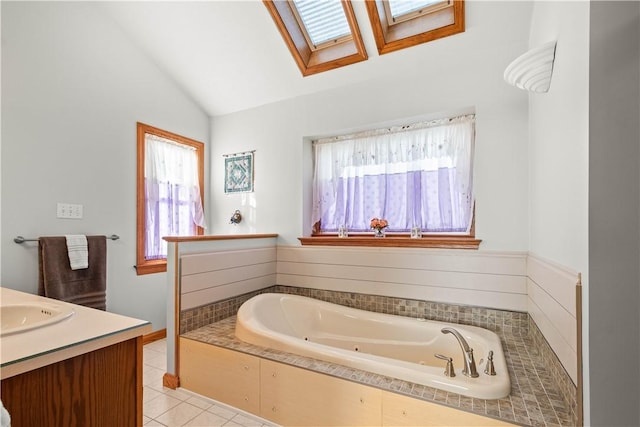 bathroom with tile patterned floors, a wealth of natural light, lofted ceiling with skylight, and tiled bath