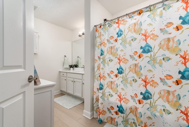 bathroom with hardwood / wood-style floors, vanity, and a shower with shower curtain