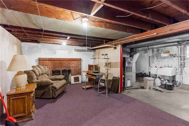 basement with a fireplace, heating unit, and sink