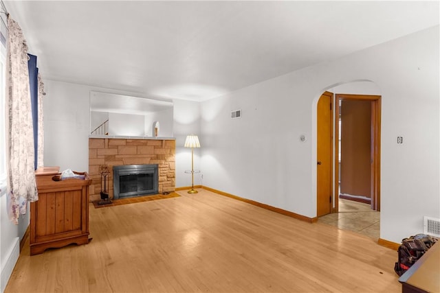 living room featuring light wood-type flooring and a fireplace