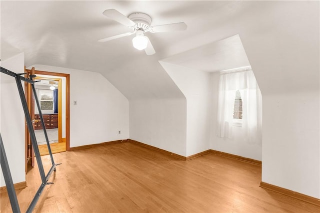 additional living space with light wood-type flooring, vaulted ceiling, and ceiling fan