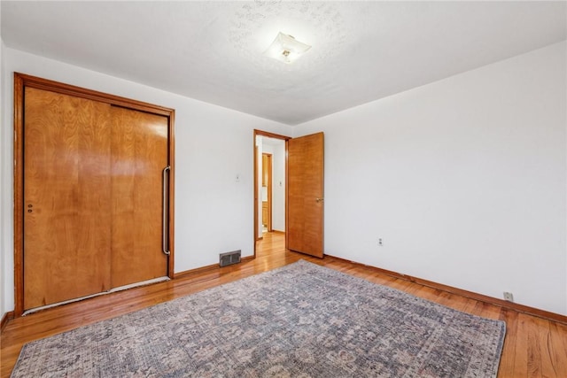 unfurnished bedroom featuring a closet and light hardwood / wood-style flooring