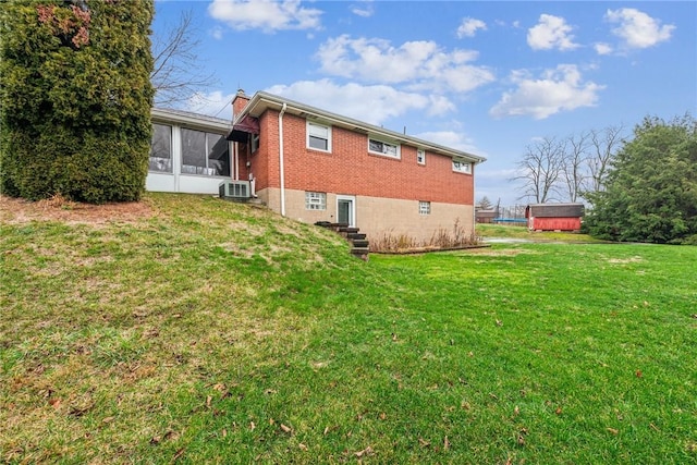 rear view of house featuring a sunroom, central AC unit, and a yard