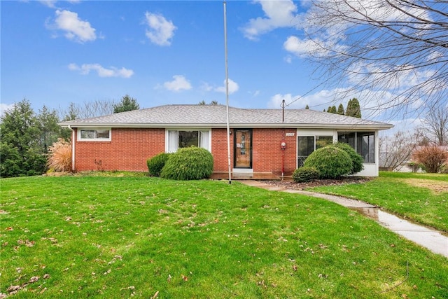 ranch-style home with a sunroom and a front lawn