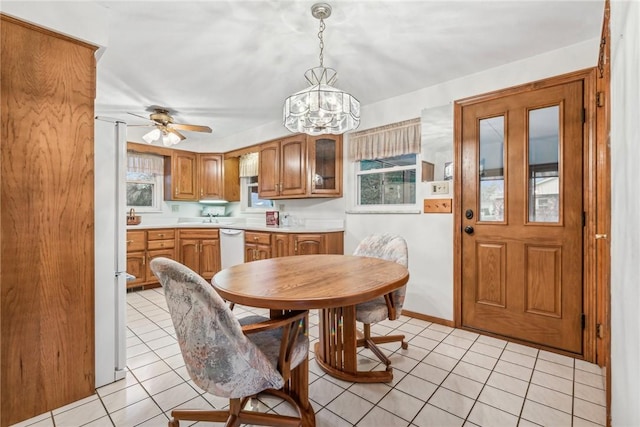 dining room with light tile patterned floors and ceiling fan with notable chandelier