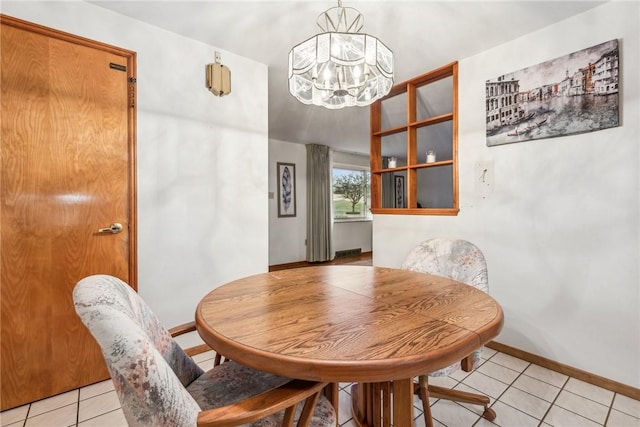 tiled dining space featuring a chandelier