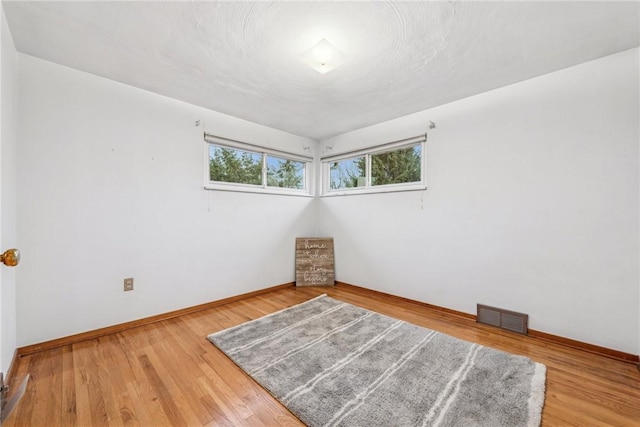 empty room with hardwood / wood-style floors