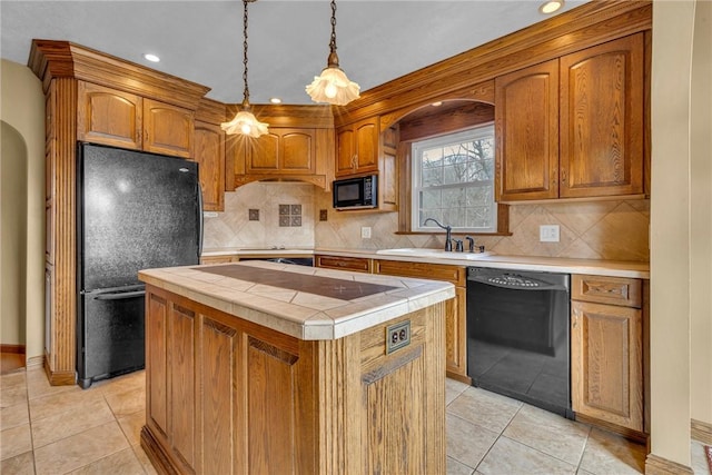 kitchen featuring pendant lighting, a center island, black appliances, sink, and decorative backsplash