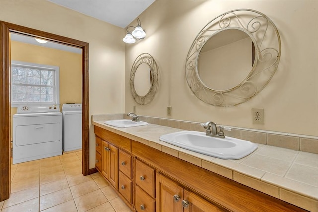 bathroom with tile patterned flooring, vanity, and washing machine and dryer