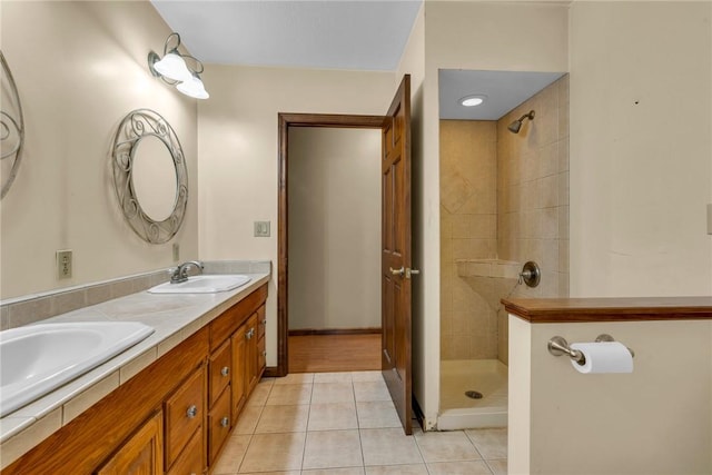 bathroom featuring a tile shower, tile patterned flooring, and vanity