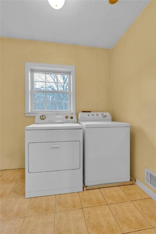 laundry area featuring washer and clothes dryer and light tile patterned floors