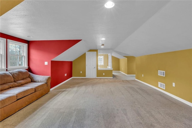 bonus room with light colored carpet and lofted ceiling