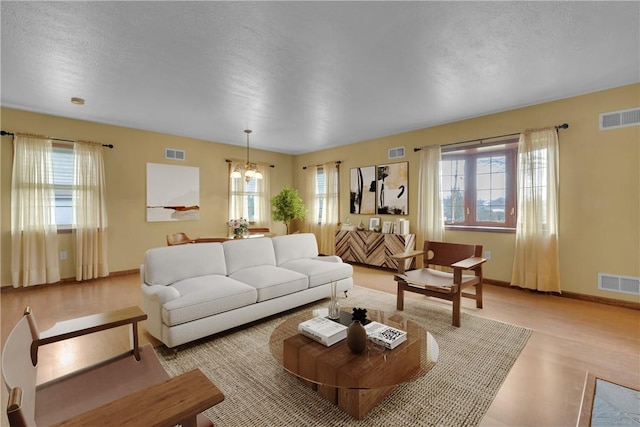 living room with light hardwood / wood-style floors and an inviting chandelier