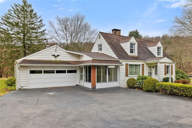 cape cod home with a sunroom and a garage