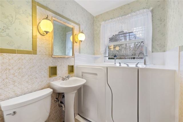 bathroom featuring toilet and tile walls