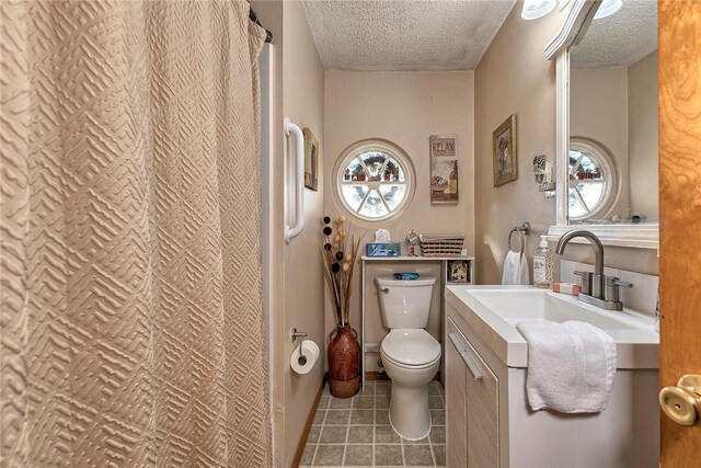 bathroom with vanity, toilet, and a textured ceiling