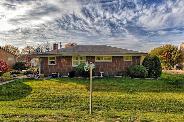 back of house featuring a lawn and central AC