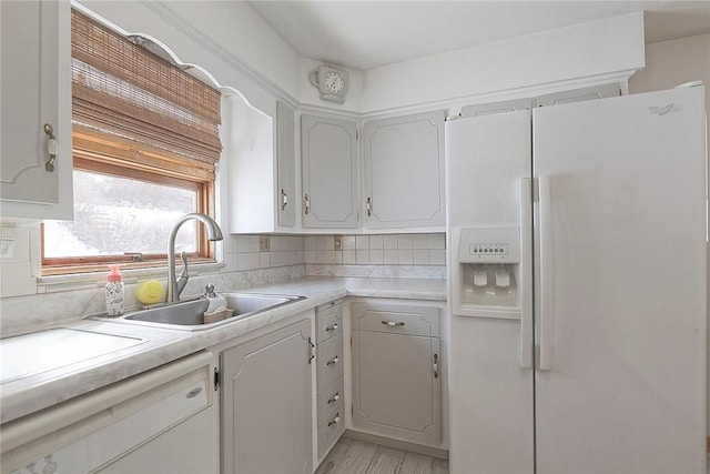 kitchen with white cabinets, decorative backsplash, white appliances, and sink