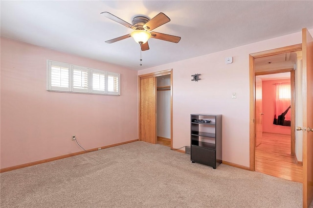 unfurnished bedroom featuring ceiling fan, a closet, and light carpet