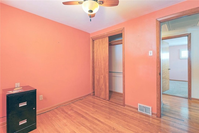 unfurnished bedroom featuring light wood-type flooring, a closet, and ceiling fan