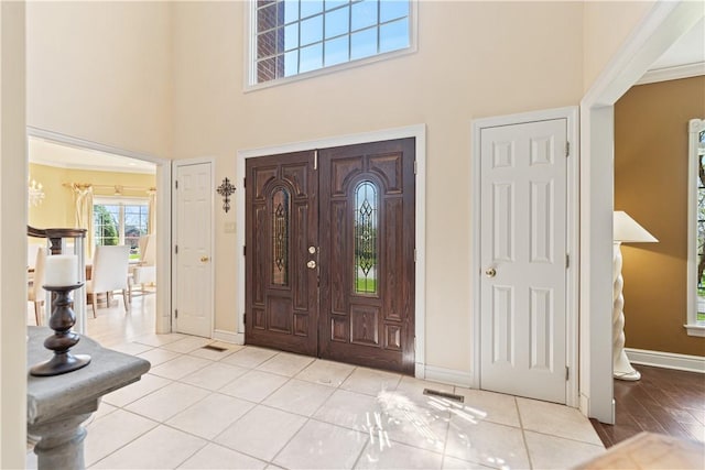 tiled foyer entrance with a towering ceiling