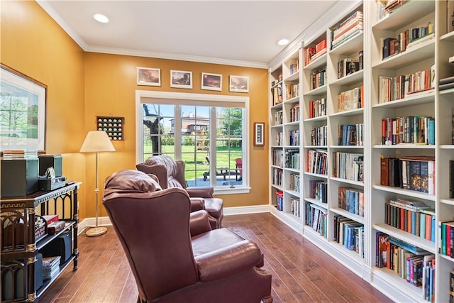 living area with wood-type flooring and ornamental molding