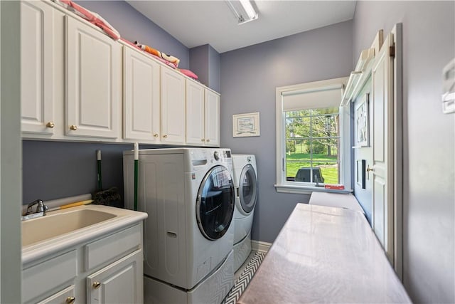 laundry area with washing machine and dryer, sink, and cabinets