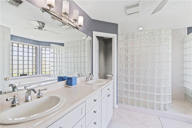 bathroom with tile patterned flooring, vanity, toilet, and walk in shower