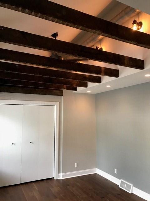 interior space featuring beamed ceiling and dark hardwood / wood-style flooring