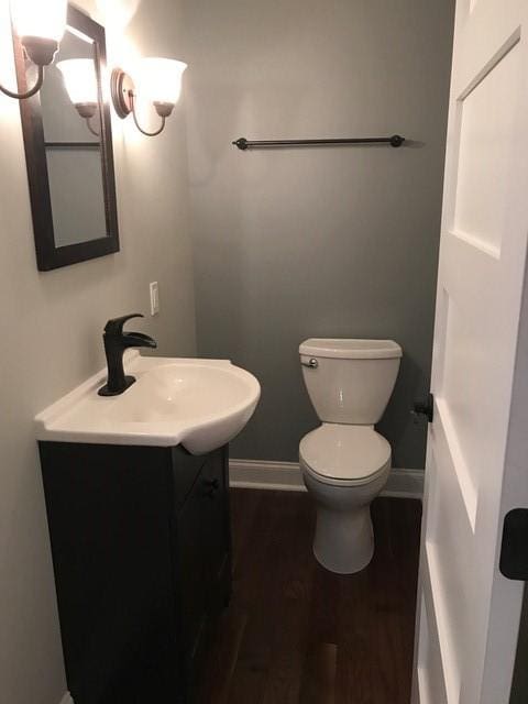 bathroom with hardwood / wood-style flooring, vanity, and toilet