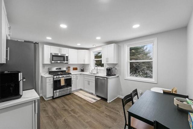 kitchen with sink, white cabinetry, stainless steel appliances, and dark wood-type flooring