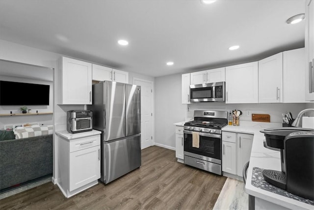 kitchen with white cabinetry, stainless steel appliances, and dark wood-type flooring