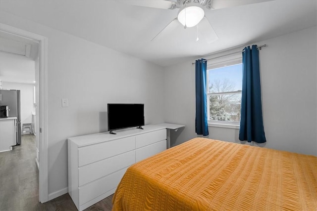 bedroom featuring hardwood / wood-style flooring, ceiling fan, and stainless steel refrigerator