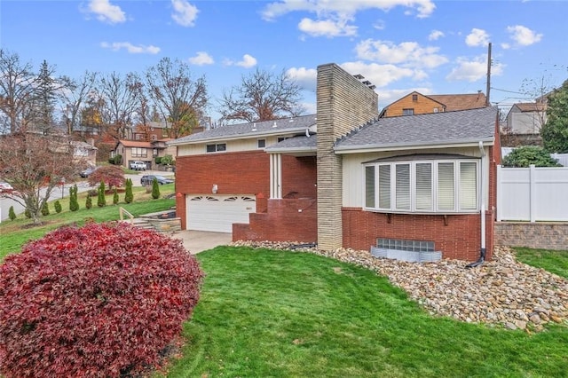 rear view of house featuring a garage and a lawn