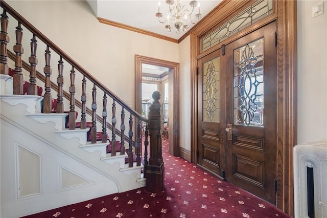 foyer entrance featuring carpet, french doors, radiator, ornamental molding, and a chandelier