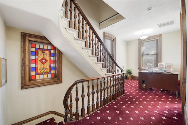 staircase featuring visible vents, carpet flooring, and baseboards