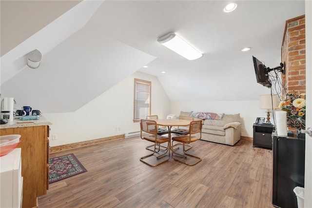 interior space with baseboards, a baseboard radiator, light wood finished floors, and vaulted ceiling