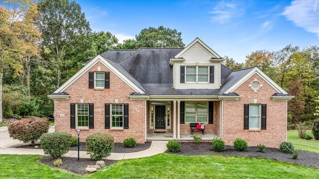 view of front of house featuring covered porch and a front yard