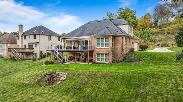 back of property with a lawn, a garage, a patio, and a wooden deck