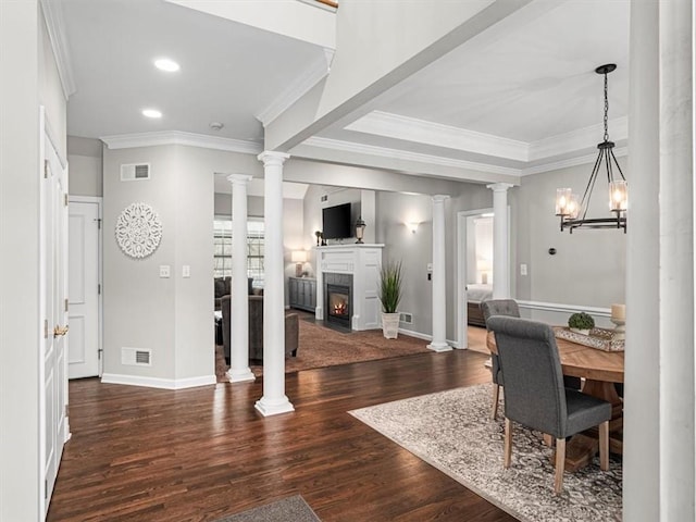 interior space with a healthy amount of sunlight, crown molding, dark wood-type flooring, and an inviting chandelier