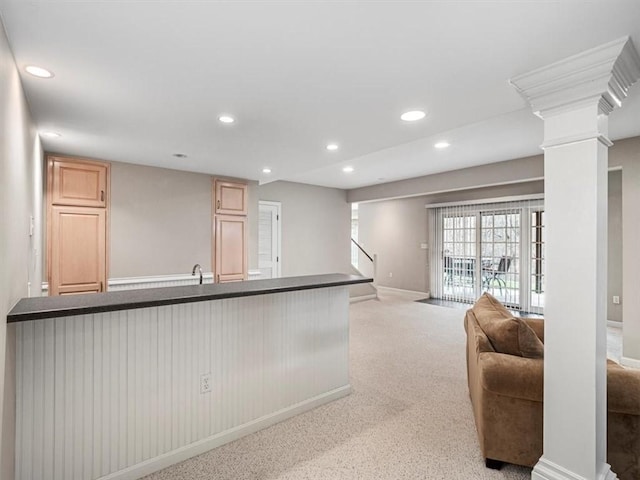 kitchen featuring light brown cabinets and light carpet