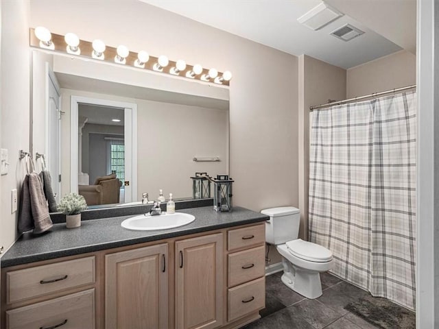 bathroom with tile patterned floors, vanity, toilet, and walk in shower