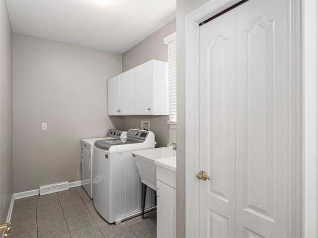 washroom with separate washer and dryer, sink, light tile patterned flooring, and cabinets