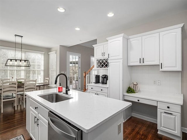 kitchen with an island with sink, white cabinetry, stainless steel dishwasher, and sink