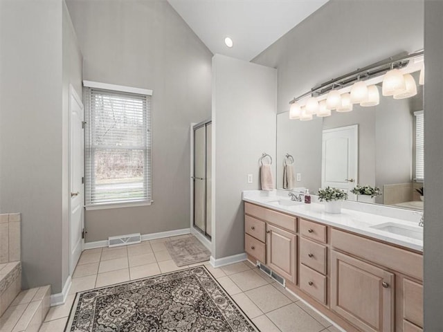 bathroom with tile patterned floors, vanity, and shower with separate bathtub